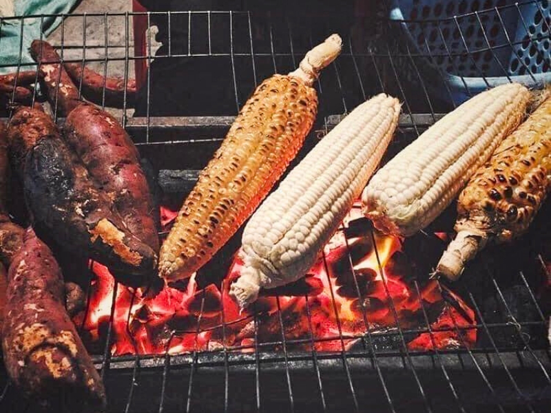 Maïs et patates douces grillés - Une collation fumée et réconfortante, incontournable des soirées hivernales à Hanoï.