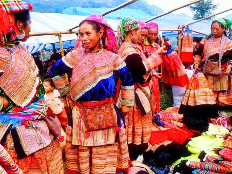 Femmes en habits traditionnels au marché de Muong Hum, reflétant la richesse culturelle locale.